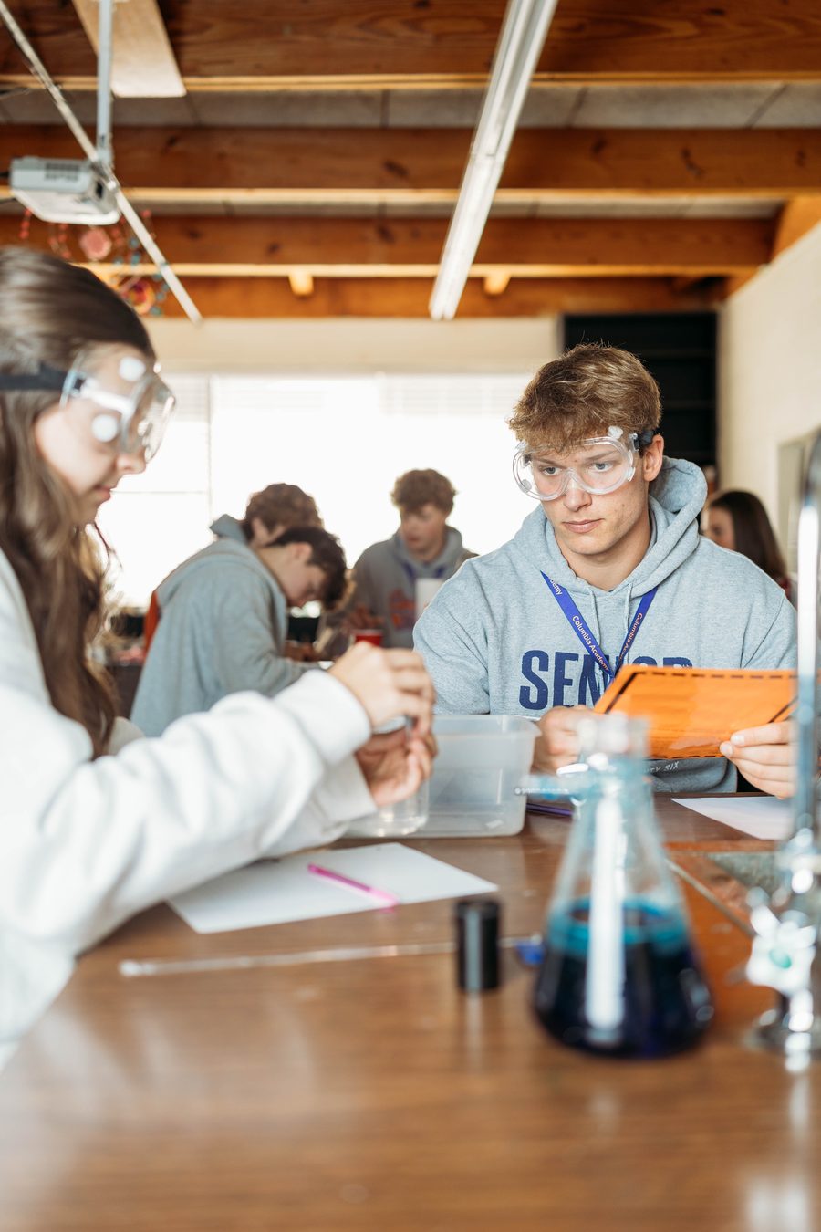 Columbia Academy high school students in a science lab wearing safety goggles