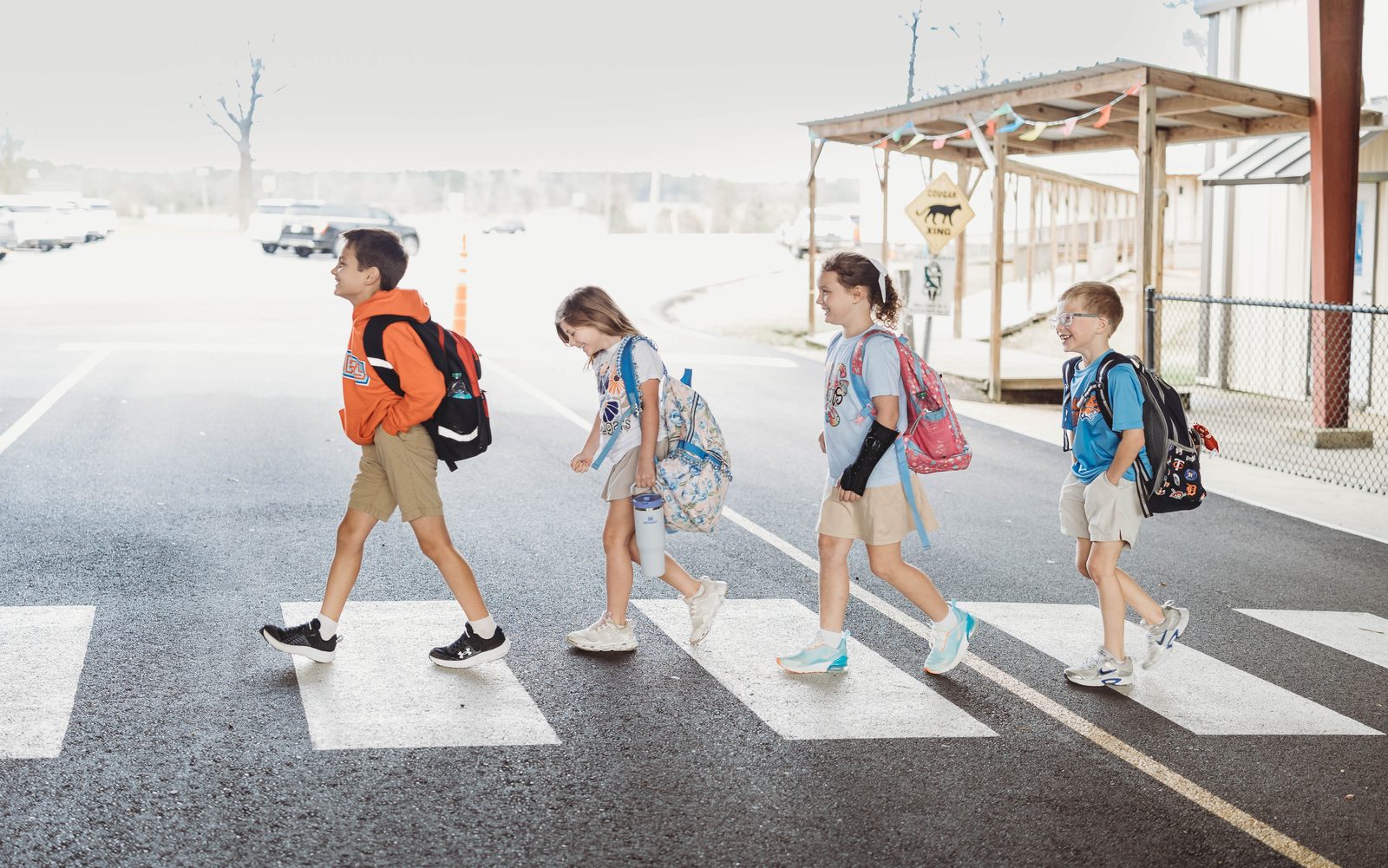 Columbia Academy students walking across the campus crosswalk with their backpacks